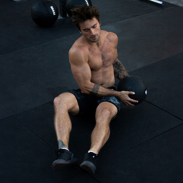 Man using 20lb Slam Ball for an ab exercise