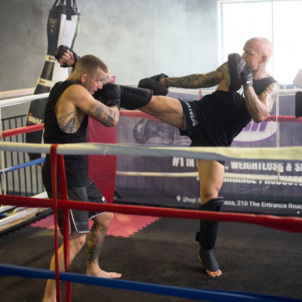 Man fighting with Elite85 Muay Thai Shin Guards