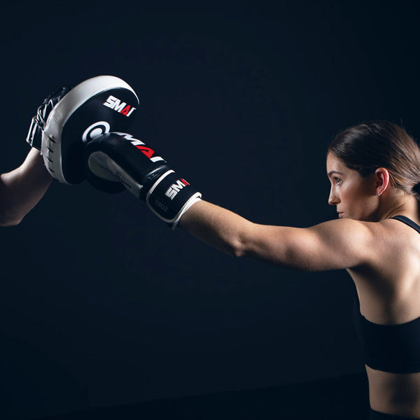 Woman Punching the SMAI Essentials Boxing Mitt