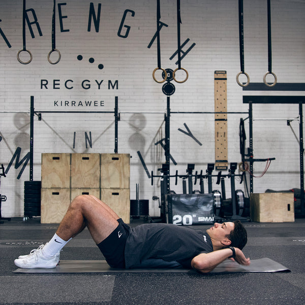 man in gym using Ab Mat, CrossFit Ab Mat, Abdominal Mat on a yoga mat laying back